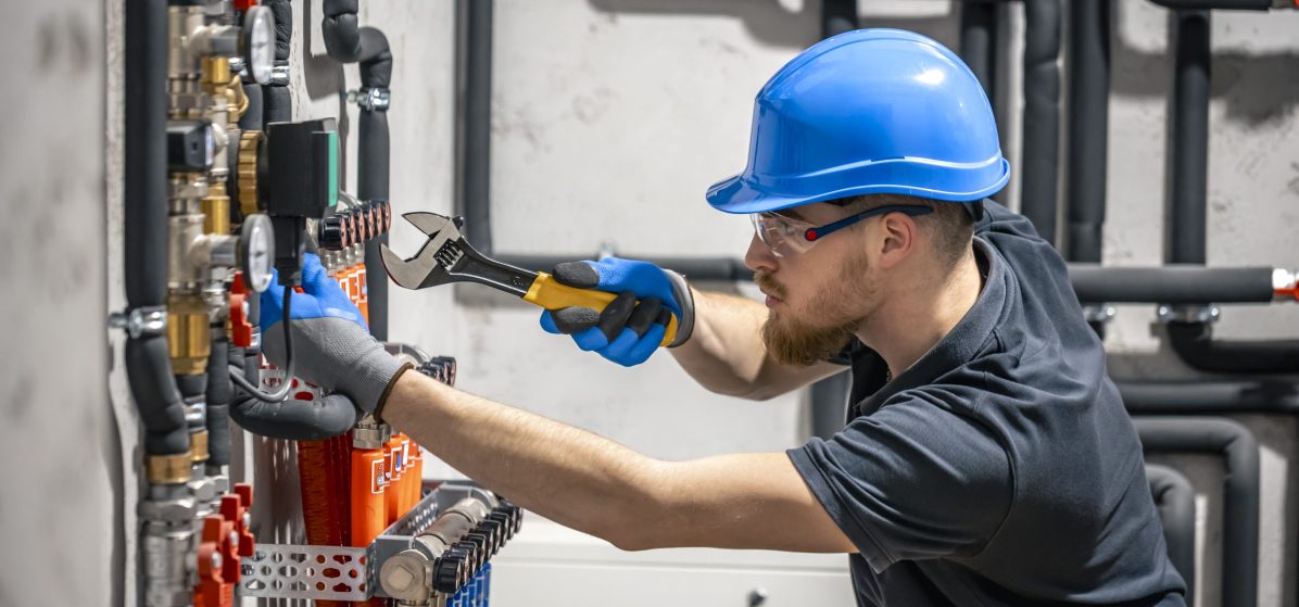 The technician checking the heating system in the boiler room. Adjusting heating valves in a residential building. A plumbing and heating technician works. SSUCv3H4sIAAAAAAAACpyS227CMAyG7yftHapcUwkSCN1eBe3COZRGhAQlKdOEePfl0CLvdnf1Z/u3/7iP97euIwKikeSze5Qox8baOaYAyXiX8Xaz8KCd0gGTe2B8iwEYHGllkg8GLIYCkpwcXHWGbra24GdNkpggzVHHssuCJCR9zhoNviTawqcWd2uiJnNHThGyQSzOorIVNfF/dbaPr5fhs3bypy6MjARtNTQjp1ZKLt9Jhyu2BrMyHrm6ewm2FDCkBOYGAf703YKRxp0R8Wmqd1mVpJ9dCmWrlxlivb+BsOXVxzxGr3yCGHO5WjmaLfNf4K9ojvOpelpUicrHKeGOsQOnx/1A+cAPR07ZUtAOOpmsU9dZhXIsL0ZhV6ZsQJTko1D00LMtHfv9B+W92B13vZJyUIOgnI003+L5CwAA//8DAEonjCm5AgAA